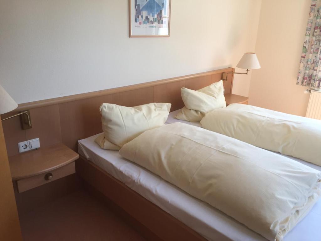 two beds in a hotel room with white pillows at Lotus Garden in Gailingen
