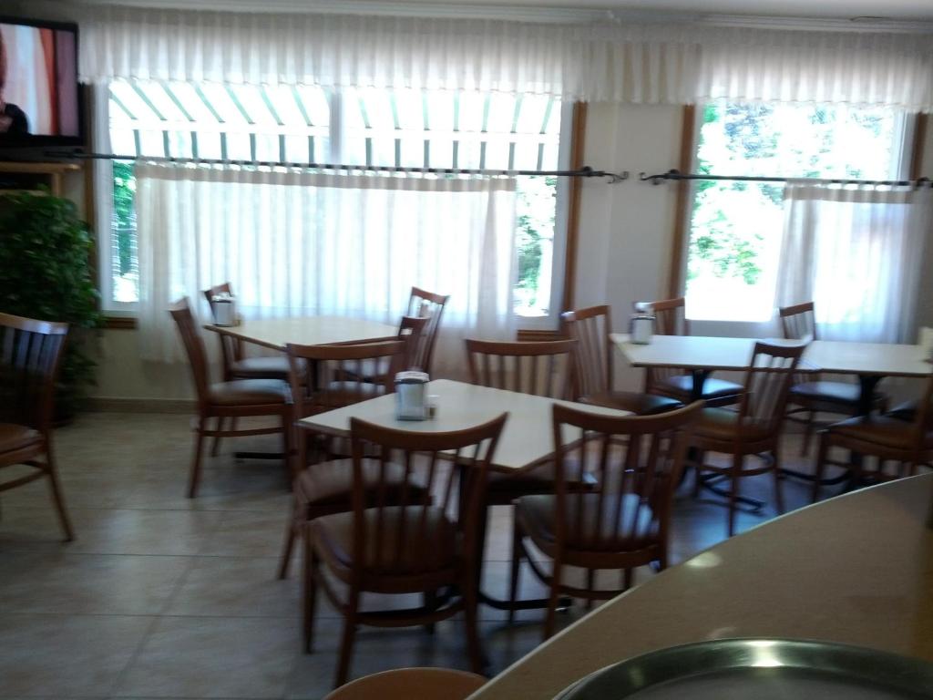 a dining room with tables and chairs and windows at Doade in Hio