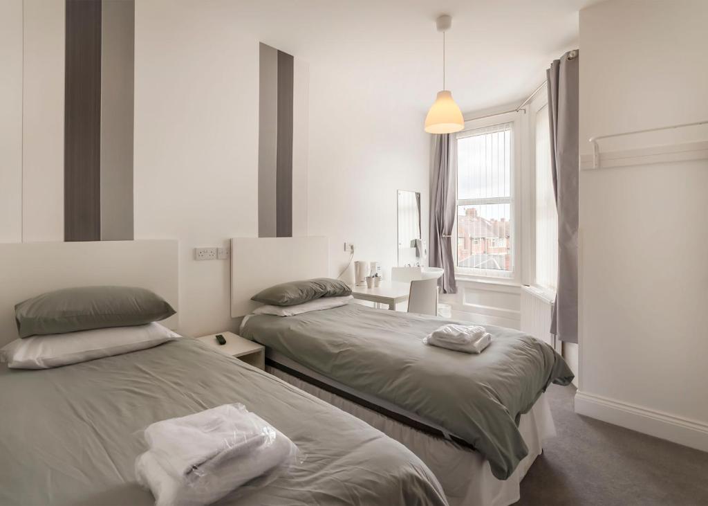 - une chambre avec 2 lits et une fenêtre dans l'établissement Kingswood Guest House, à Stockton-on-Tees