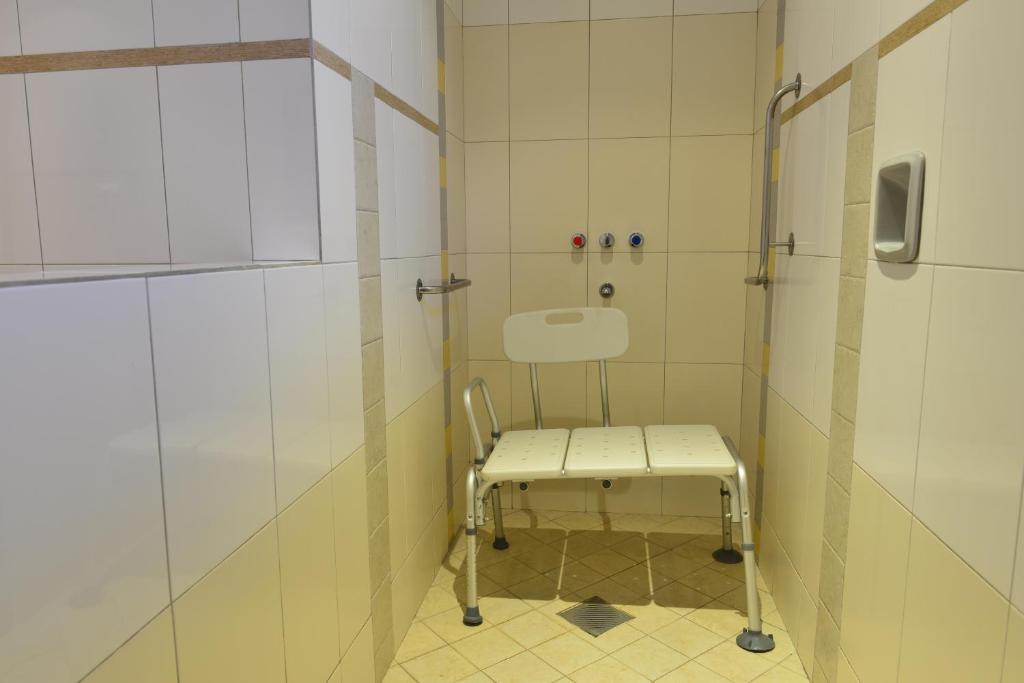 una doccia con sedia in bagno di Hotel Restaurant Papillon a Bella Vista