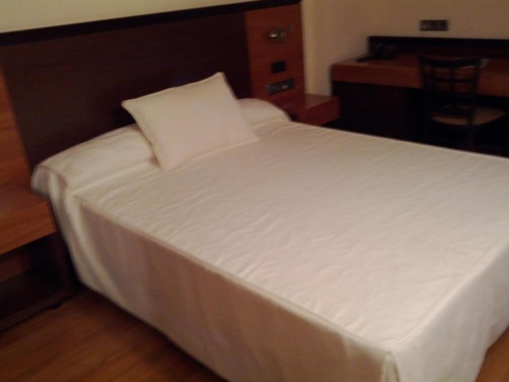 a large white bed in a room with a table at Doade in Hio