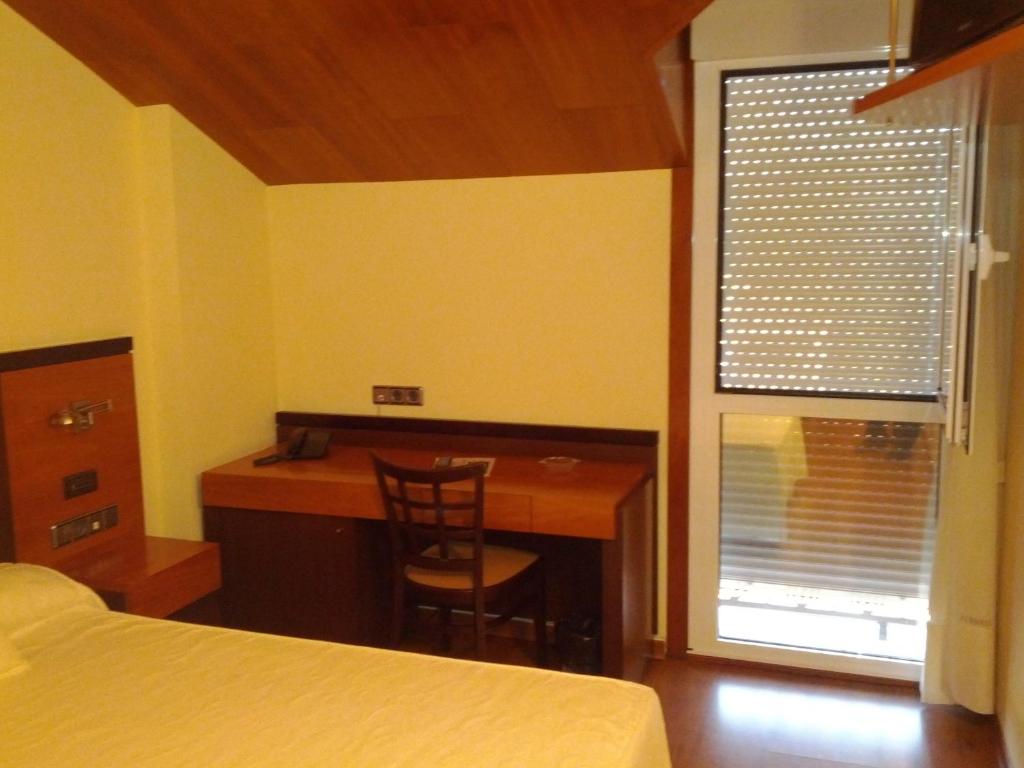 a bedroom with a desk and a bed and a window at Doade in Hio