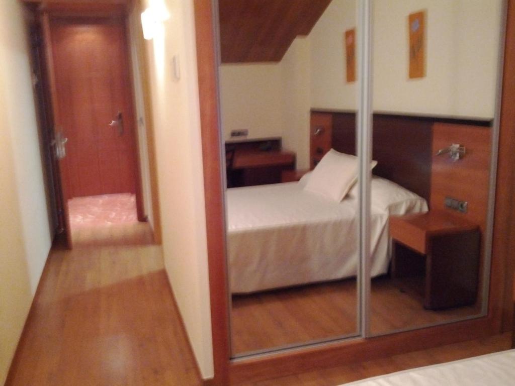 a bedroom with a bed and a mirror in a room at Doade in Hio