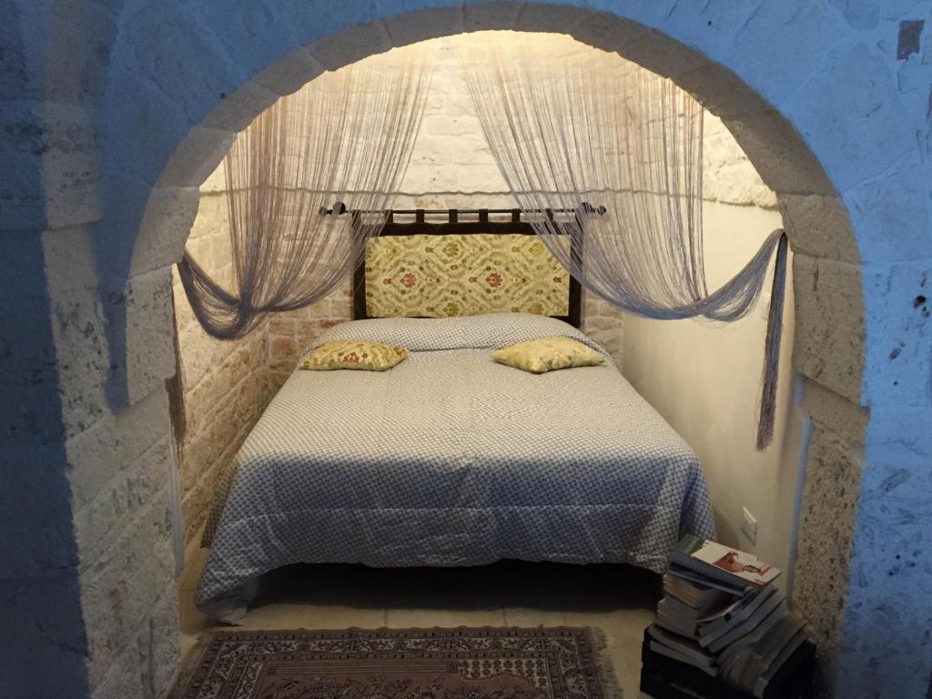 sypialnia z łóżkiem łukowym w obiekcie Trullo Dell’Antica Fileria w Alberobello