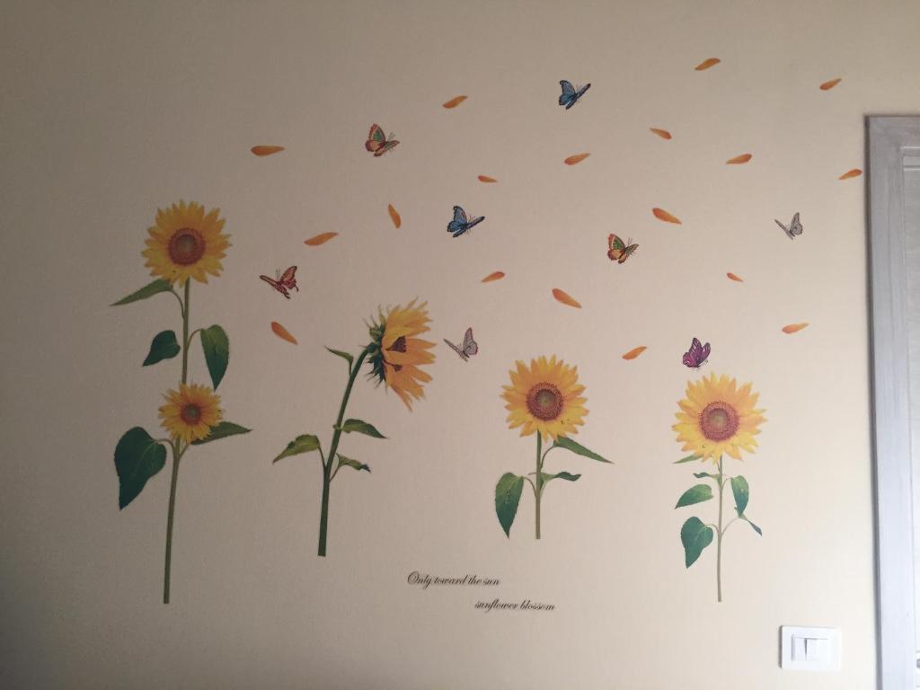 a wall mural of sunflowers and butterflies at Limone & Girasole in Fiumefreddo di Sicilia