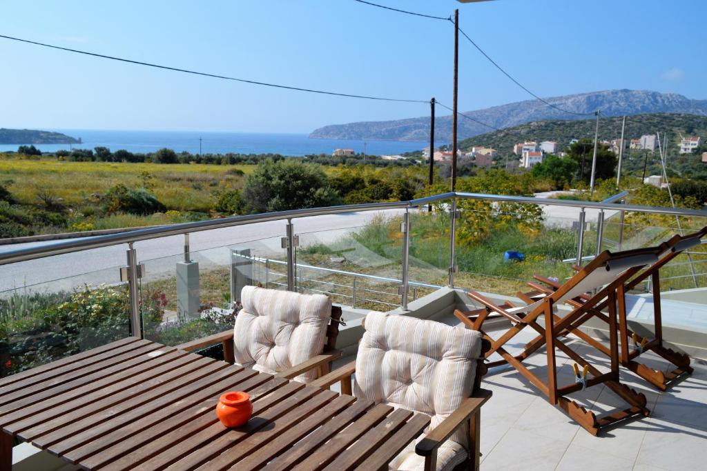 a balcony with a wooden table and two chairs at Sandra's Sea View at Sounio in Sounio