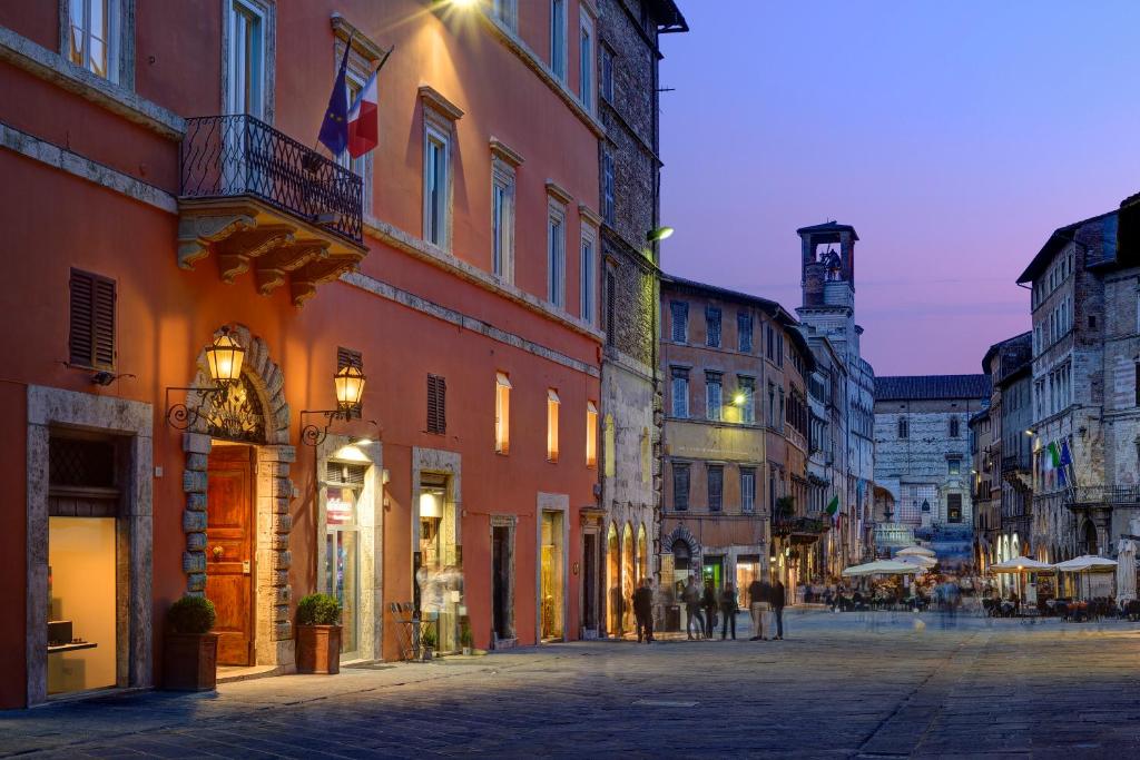 a city street with buildings and people walking down a street at Locanda della Posta Boutique Hotel in Perugia