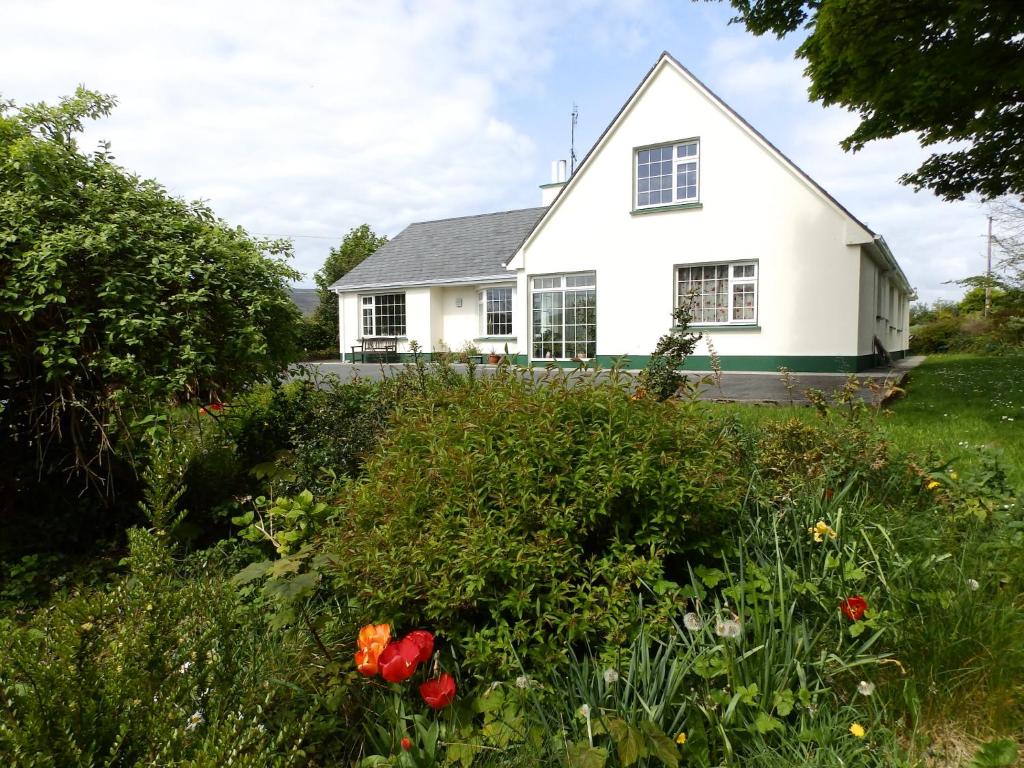 a white house with flowers in front of it at Meadowfield in Ballyvaughan