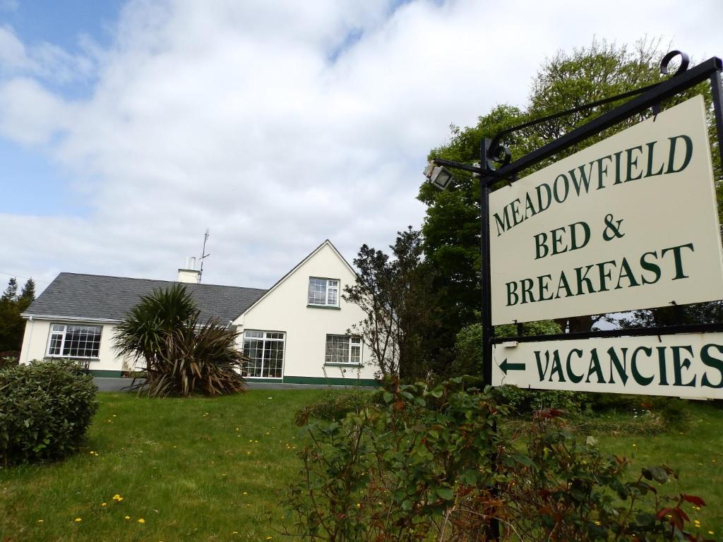 un cartel para un bed and breakfast frente a una casa en Meadowfield Bed And Breakfast, en Ballyvaughan