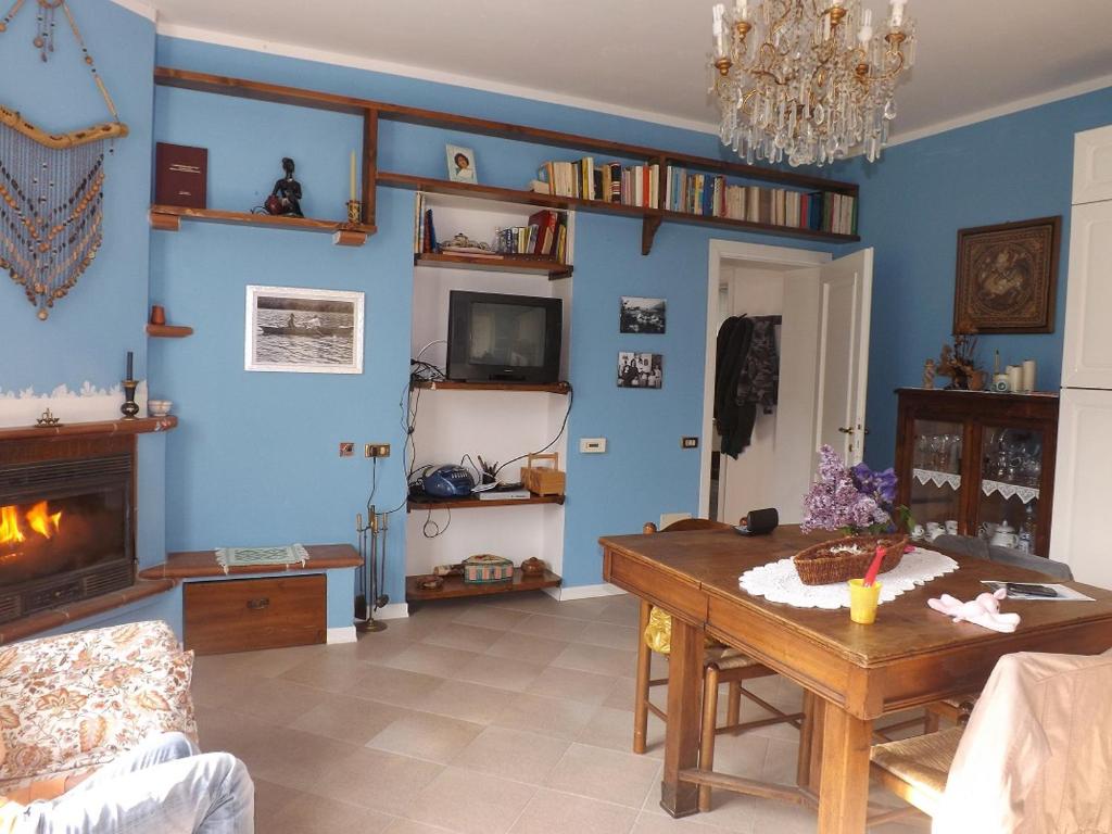Villa Glicine في Apecchio: غرفة معيشة مع طاولة ومدفأة