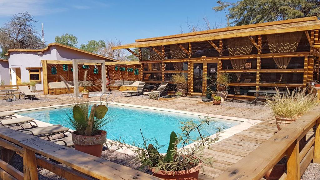 a house with a swimming pool in front of it at Hotel La Cochera in San Pedro de Atacama