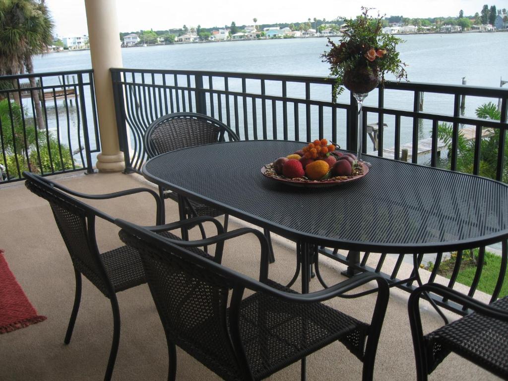 a black table with a bowl of fruit on a balcony at Beach and Bay MediterraneanTownhouse in St Pete Beach