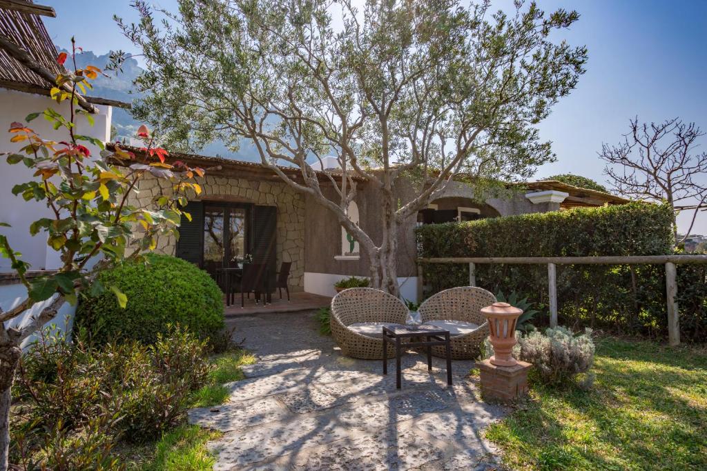 a patio with a table and chairs in front of a house at Tenuta Del Poggio Antico in Ischia