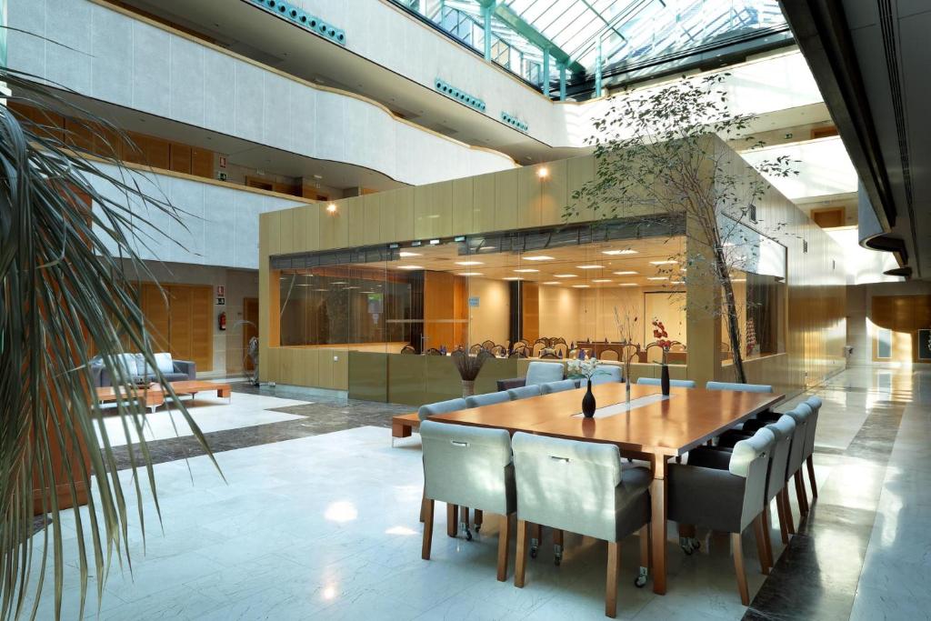 a large dining room with a table and chairs at Exe Gran Hotel Almenar in Las Rozas de Madrid