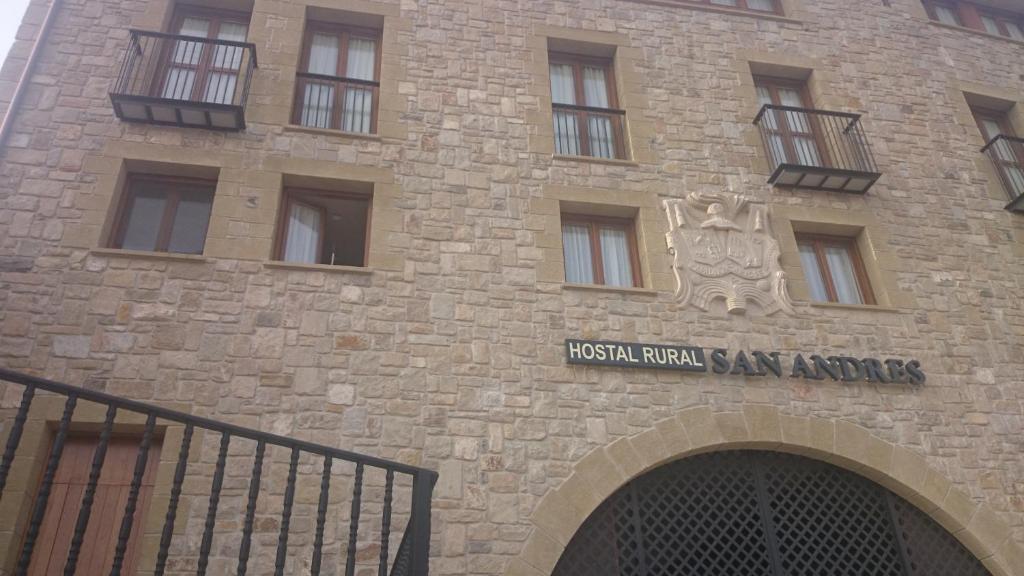 a brick building with a sign on the side of it at Hostal Rural San Andrés in Torres del Río