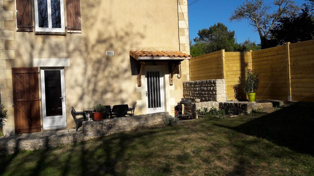 a house with a fence and a yard with chairs at l'escale in Montamisé