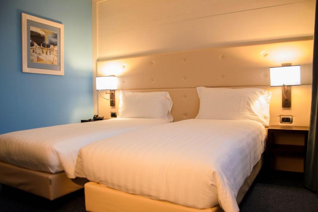 Postel nebo postele na pokoji v ubytování Palace Hotel Legnano