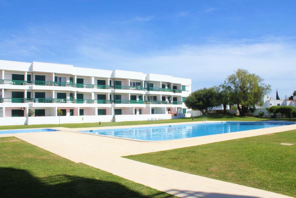 a large apartment building with a large swimming pool at Vilamoura Dolphin Studio in Vilamoura