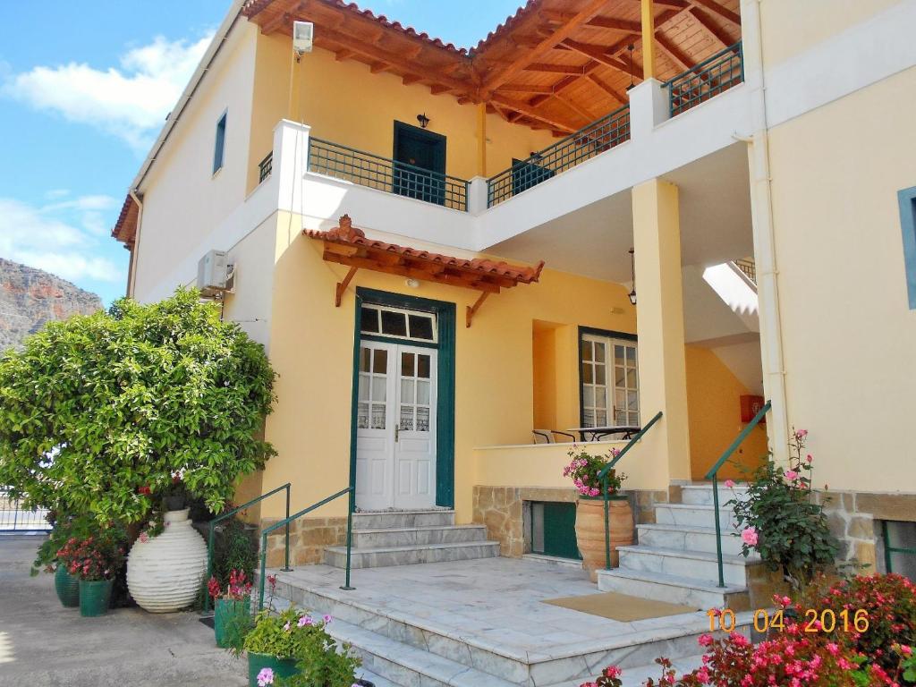 una casa con una puerta azul y escaleras en Costa-Rini Hotel, en Leonidio