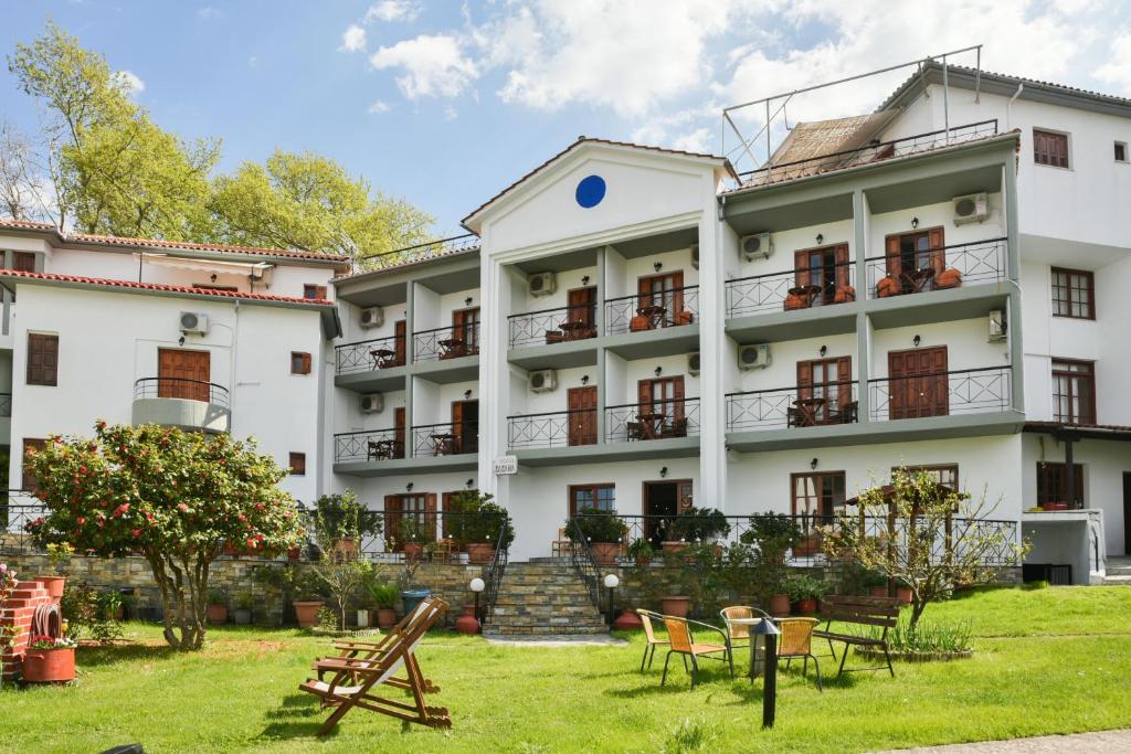 duży biały budynek z ogródkiem przed nim w obiekcie Hotel Eleana w mieście Agios Ioannis Pelio