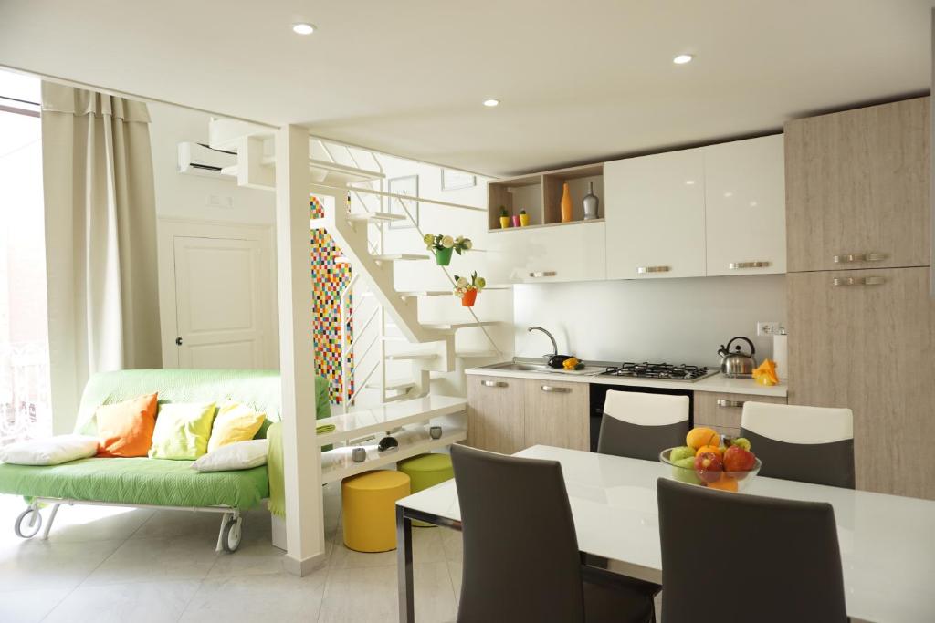 una cucina e un soggiorno con divano verde di Dante Home - Bari Centro a Bari
