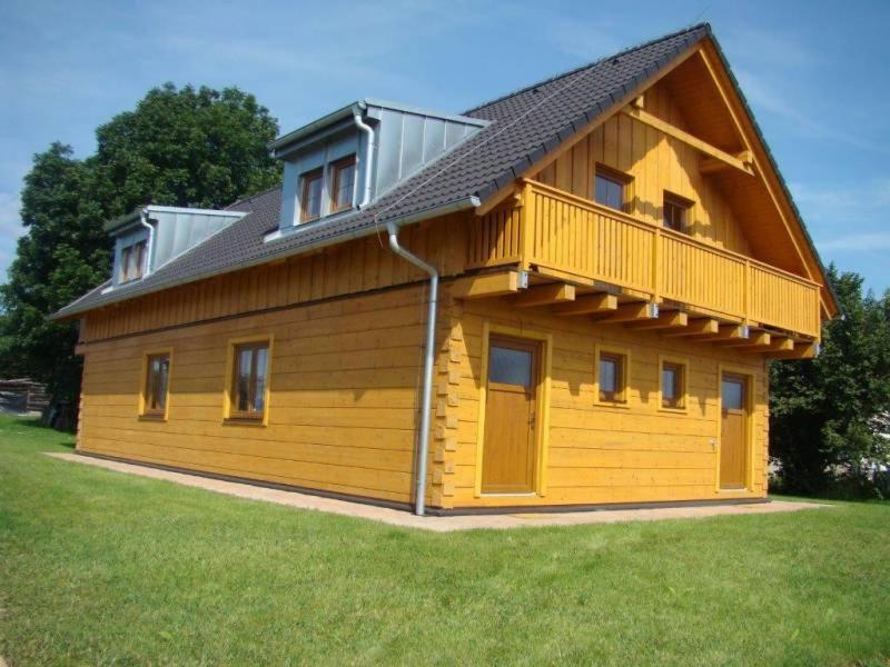 une grande maison en bois avec un toit en gambrel dans l'établissement Roubenka U Třeboně, à Domanín