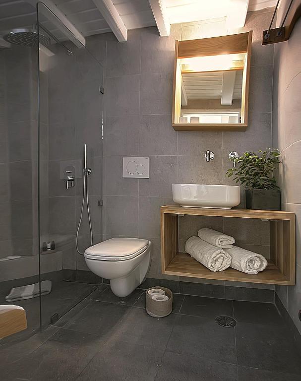 uma casa de banho com um WC, um lavatório e um espelho. em Glaros Studios em Naxos Chora