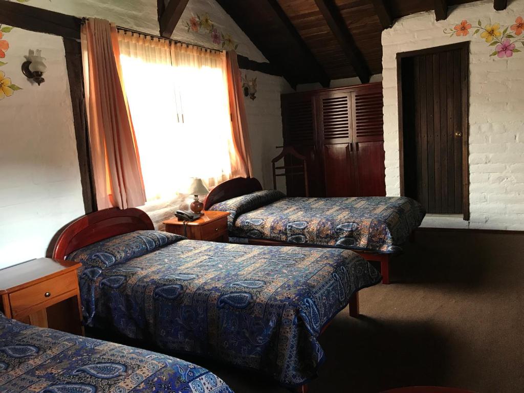 Postel nebo postele na pokoji v ubytování Hotel y Hosteria Natabuela