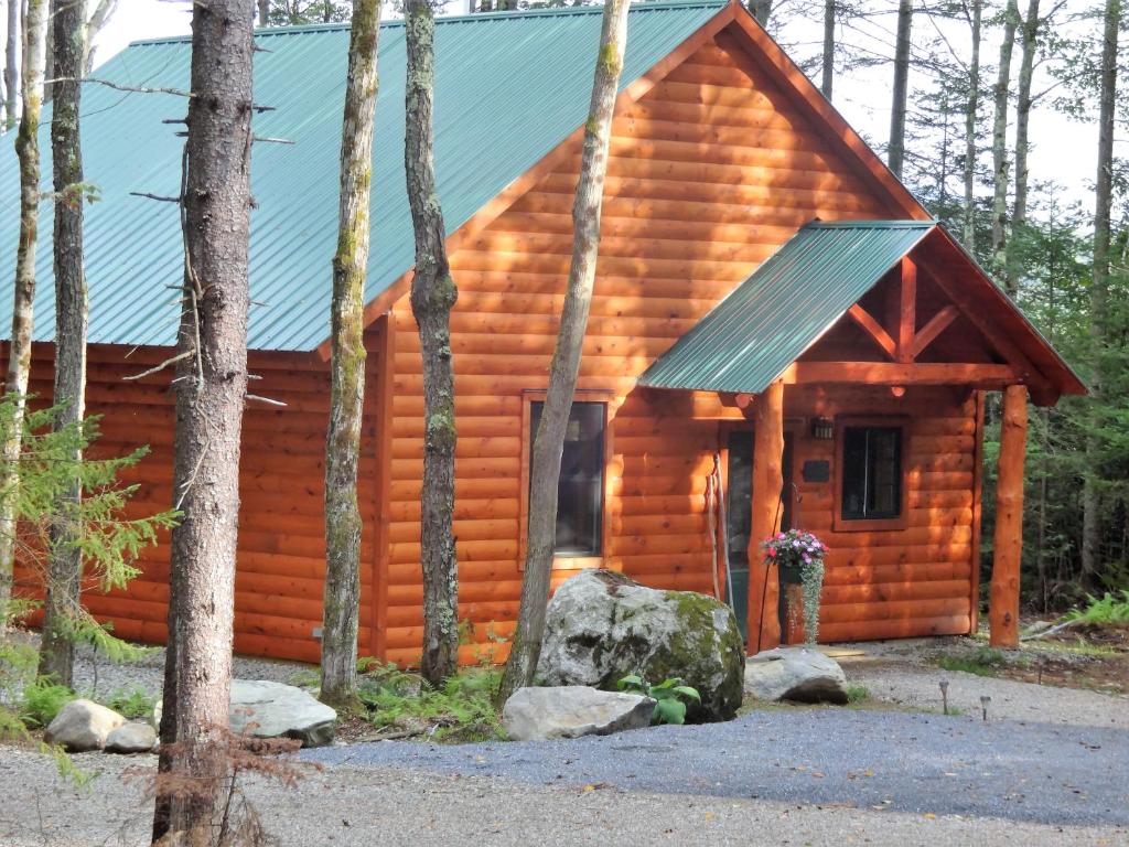 Cabaña de madera con techo verde en Robert Frost Mountain Cabins, en Middlebury