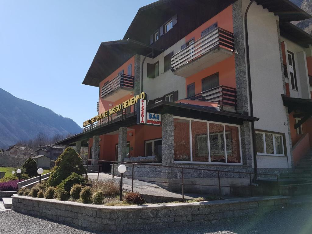 un bâtiment avec un panneau sur son côté dans l'établissement Hotel Ristorante Sasso Remenno, à Val Masino