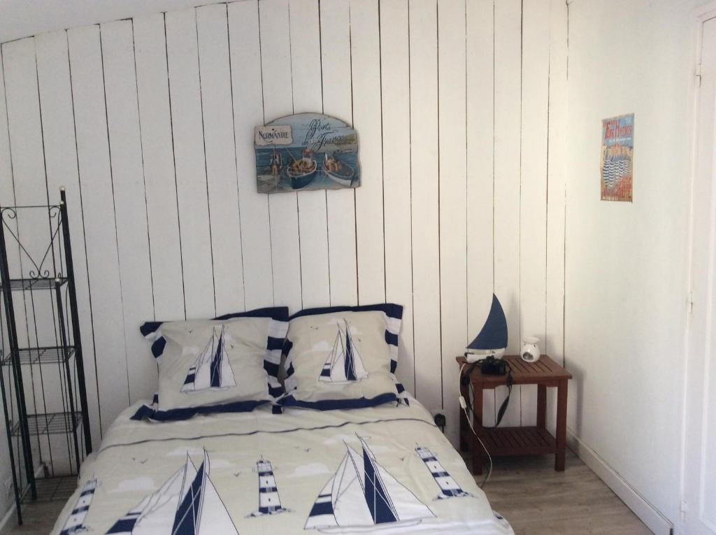 a bedroom with a bed with blue and white pillows at Appartement vue sur le port de Dieppe in Dieppe