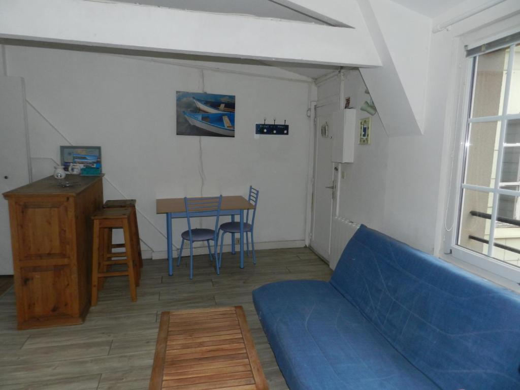 a living room with a blue couch and a table at Appartement vue sur le port de Dieppe in Dieppe