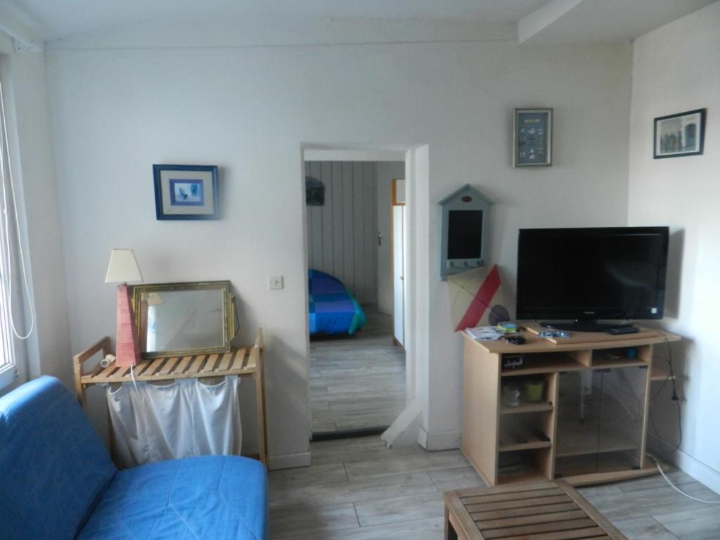 a living room with a blue couch and a television at Appartement vue sur le port de Dieppe in Dieppe