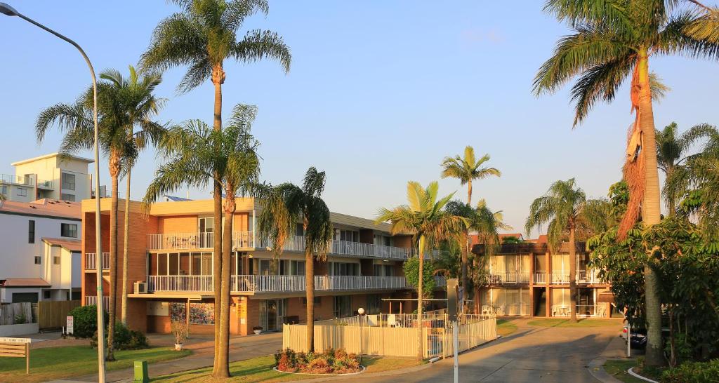 una calle con palmeras frente a un edificio en Jadran Motel & El Jays Holiday Lodge, en Gold Coast