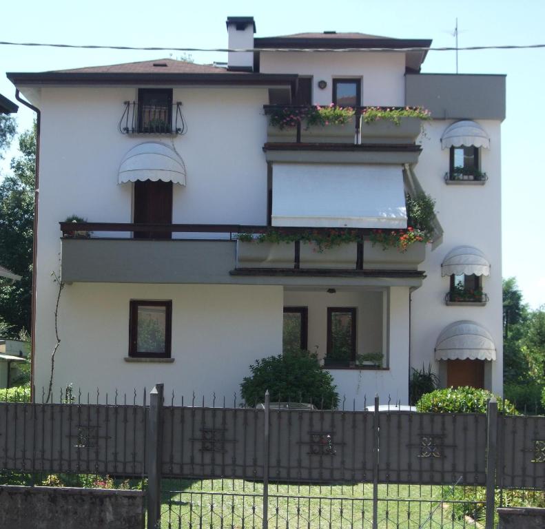 uma casa branca com caixas de flores e uma cerca em Casa Vacanze Boario em Boario Terme