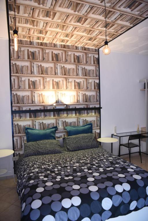 a bedroom with a bed and a wall of books at la casa di asmei b & b Lucera in Lucera