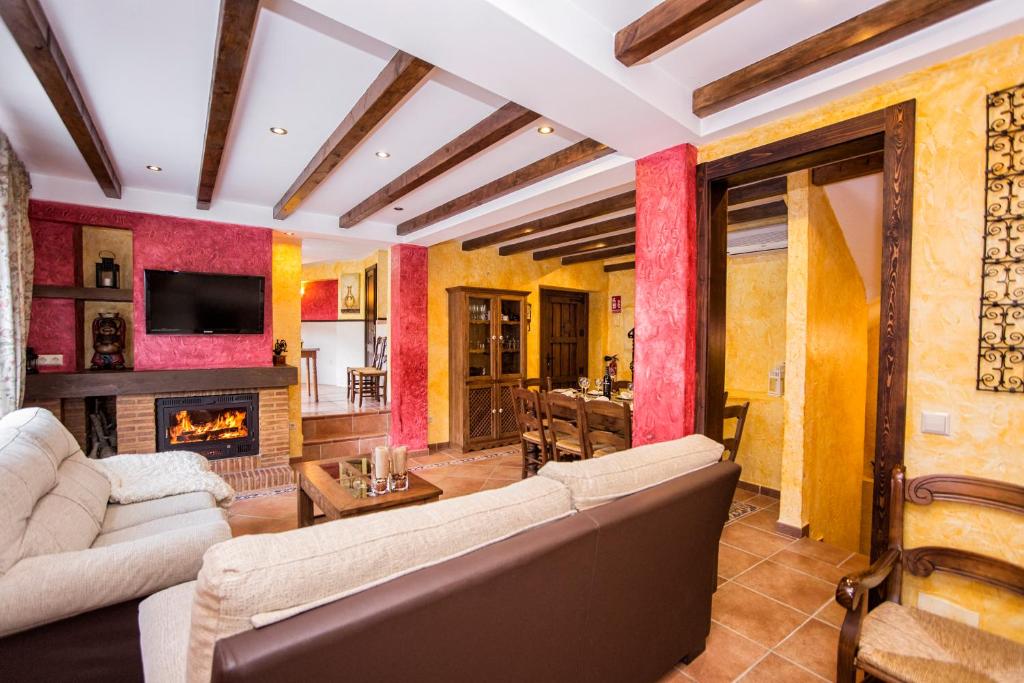 a living room with a couch and a fireplace at Casa Valle del Genal in Igualeja