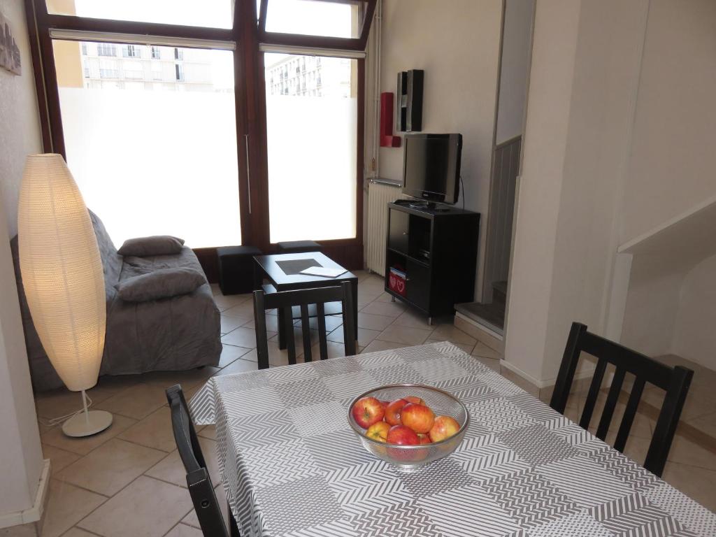 a living room with a table with a bowl of fruit on it at Gîte du Vieux Marché in Le Havre