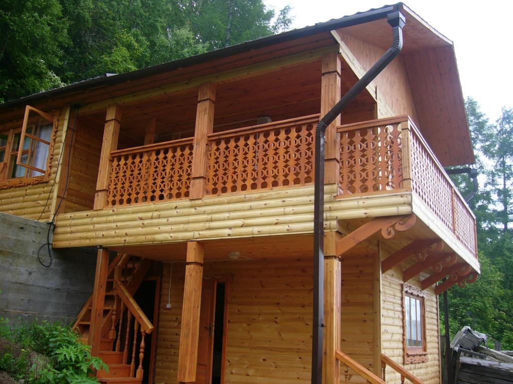 リストヴャンカにあるSinilga MiniHotelのバルコニー付きの大きな木造家屋