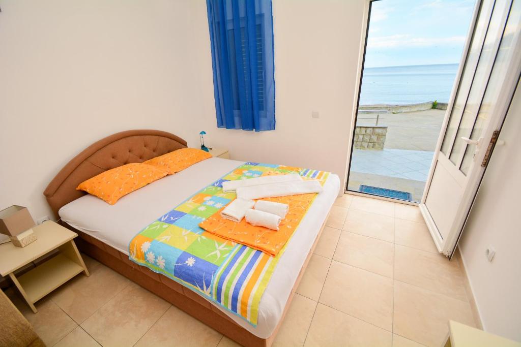 a bedroom with a bed with a view of the ocean at Apartments Kristina Jaz Budva in Budva