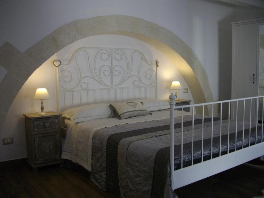 um quarto com uma cama grande e 2 candeeiros em Pied a Terre Aretusa em Siracusa