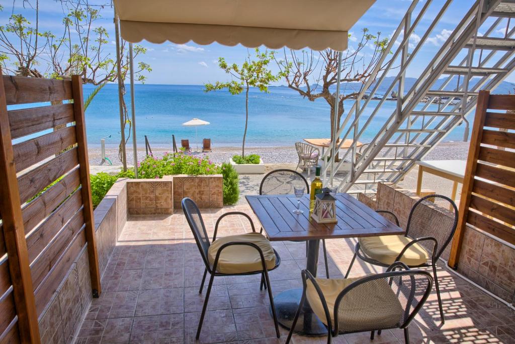 un patio con mesa y sillas y la playa en Haraki Dream View, en Charaki