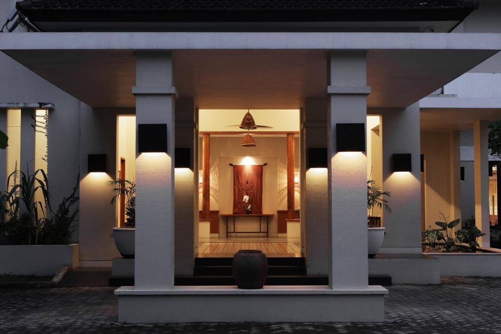 a house with columns and a hallway with a doorway at Billiton Hotel in Tanjungpandan