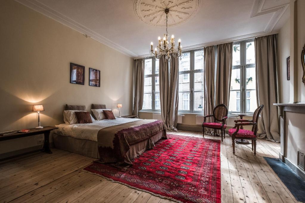 a bedroom with a large bed and a red rug at Braamberg B&B in Bruges