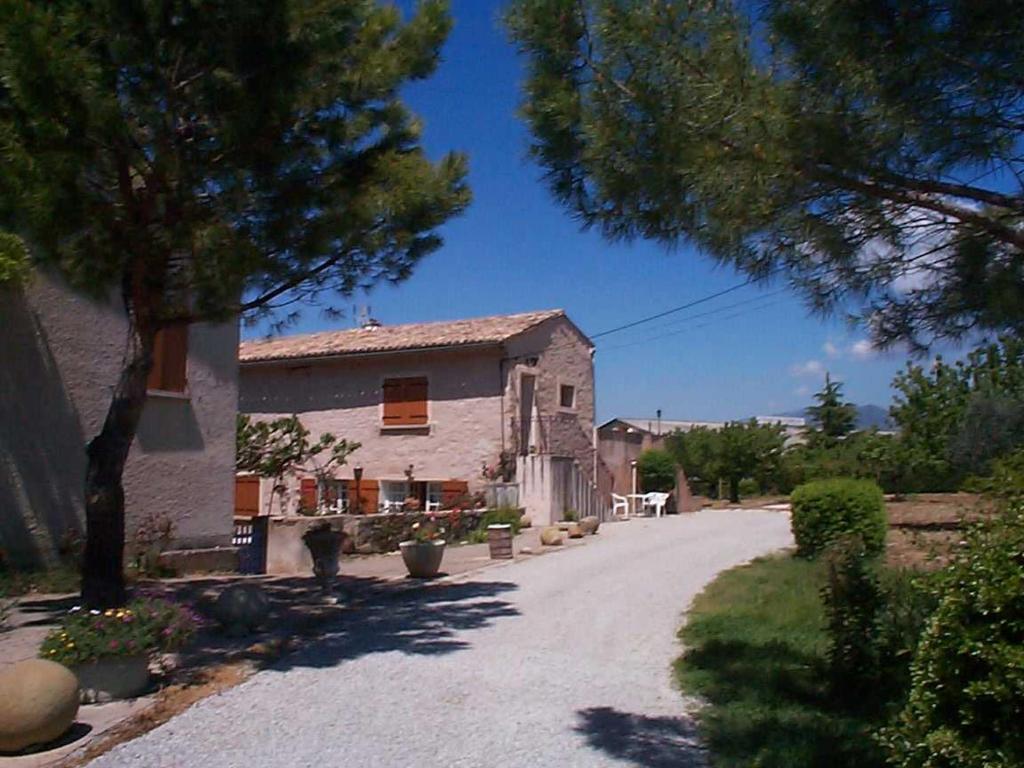 a house with a tree in front of a driveway at Mas du Prescondu in Mirabel-aux-Baronnies