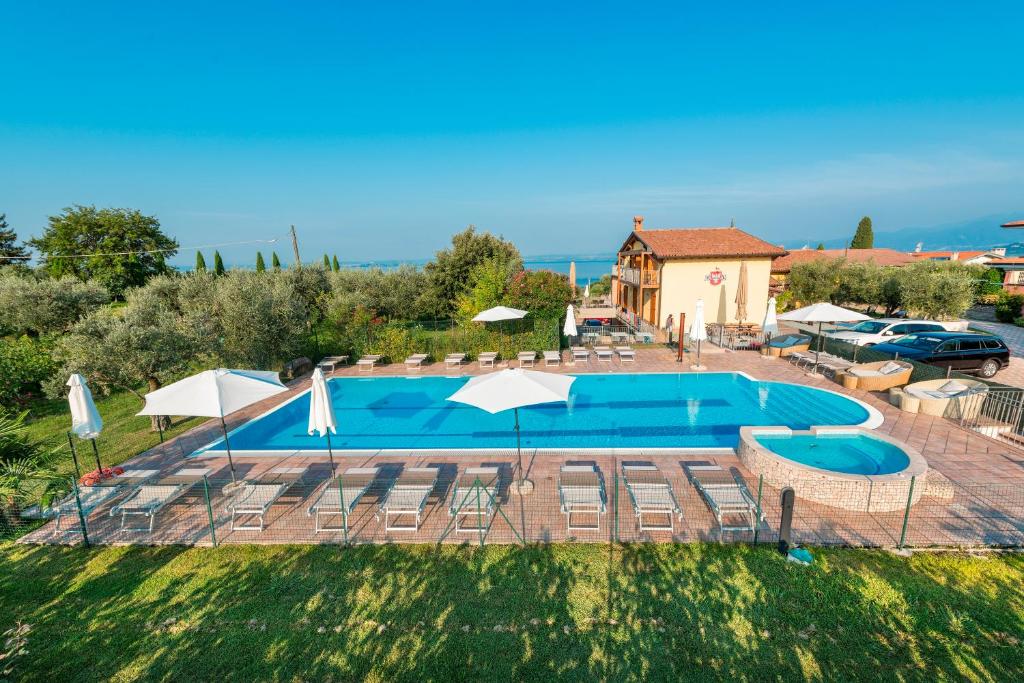 a large swimming pool with chairs and umbrellas at Agriturismo Costadoro in Bardolino
