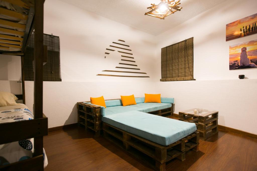 Habitación con cama con almohadas de color naranja y azul. en Douro Surf Hostel en Vila Nova de Gaia