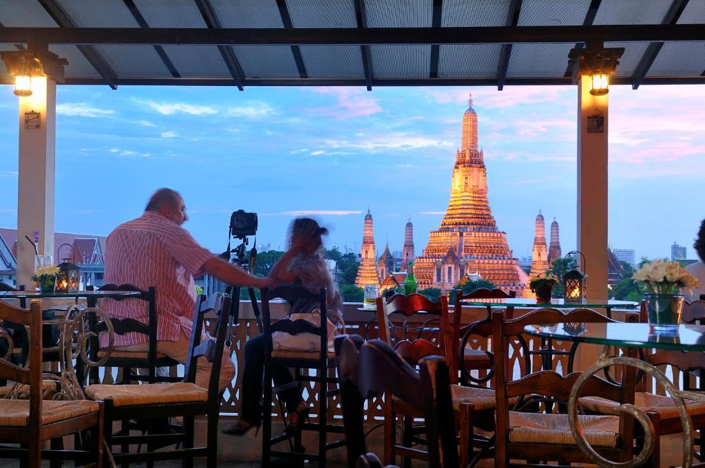 
people sitting at tables in a restaurant at Arun Residence in Bangkok
