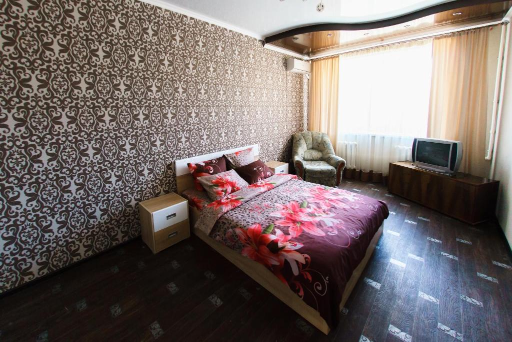 1 dormitorio con 1 cama y TV. en Apartment on Gagarina 27/6 en Oremburgo