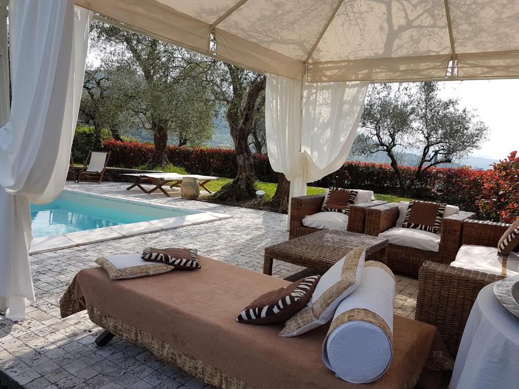 a pavilion with chairs and a pool in a house at Villa Altar in Bolano